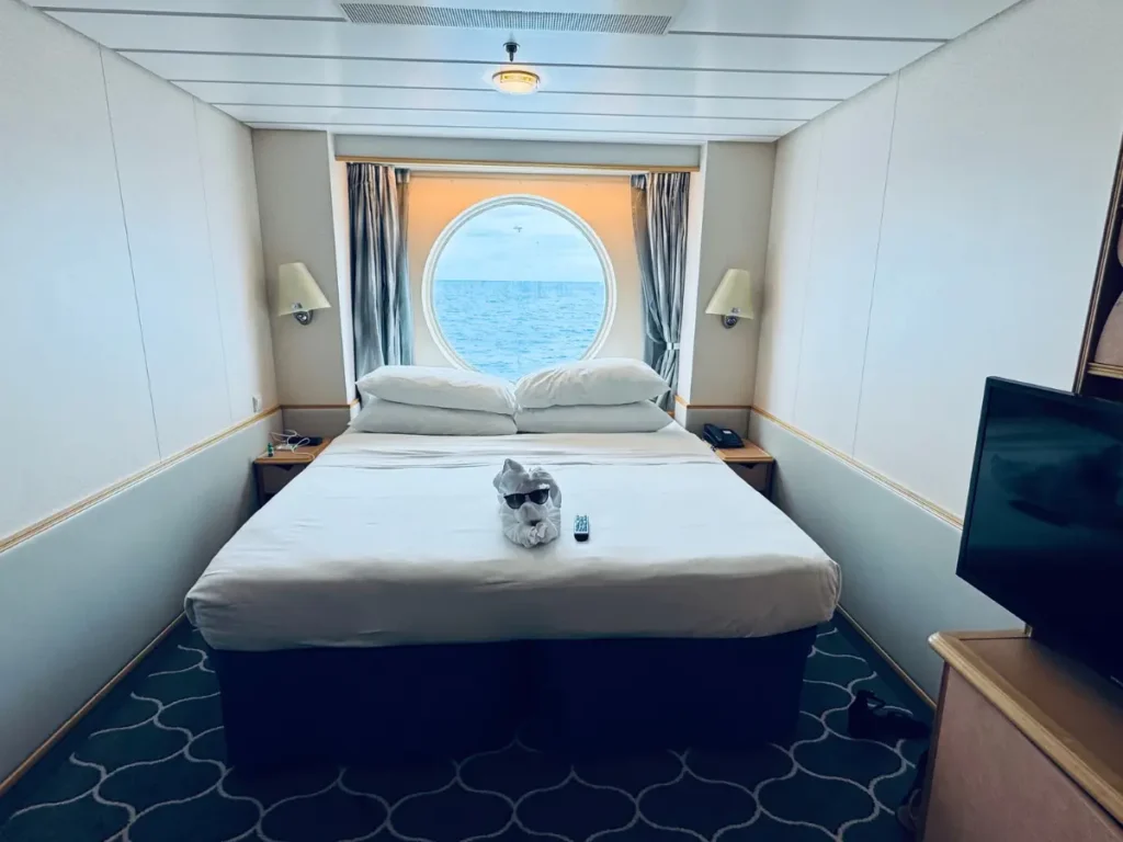 Interior view of a stateroom on Royal Caribbean's Adventure of the Seas featuring a large window overlooking the ocean.
