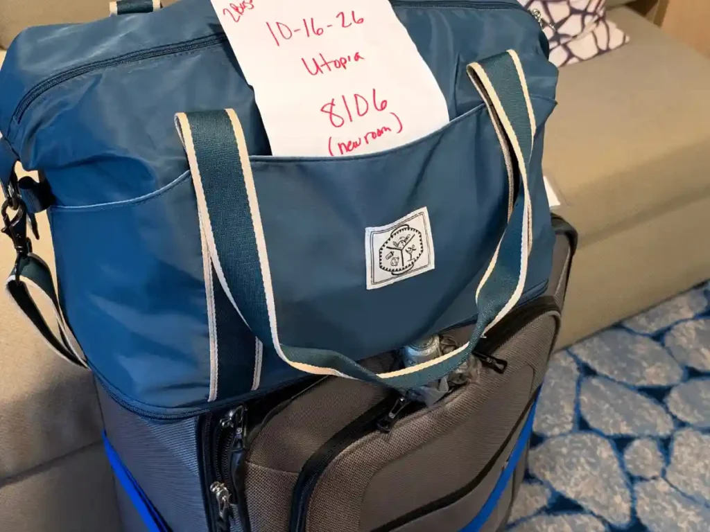 Carry-on luggage bag with a back-to-back turnaround note tucked in the pocket during the Utopia of the Seas changeover day.
